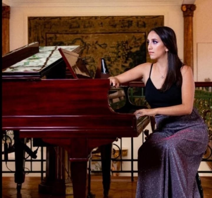 Mujer recargada en un piano cafe