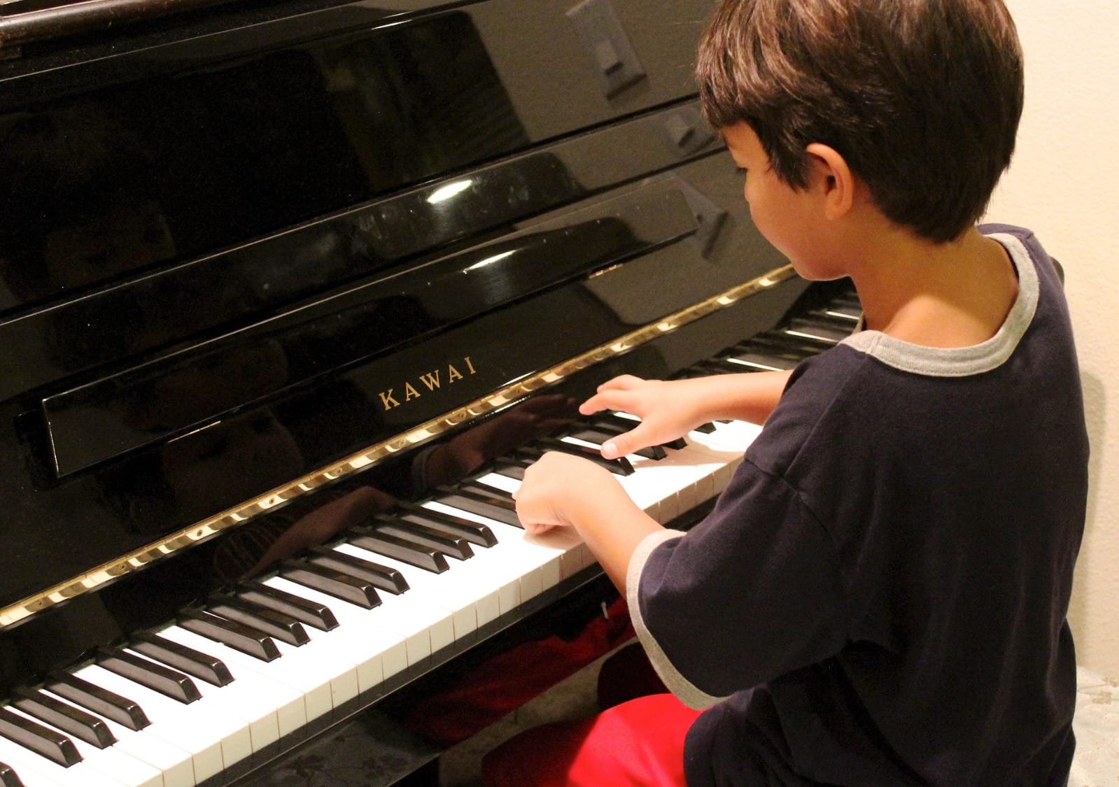 Niño tocando piano negro