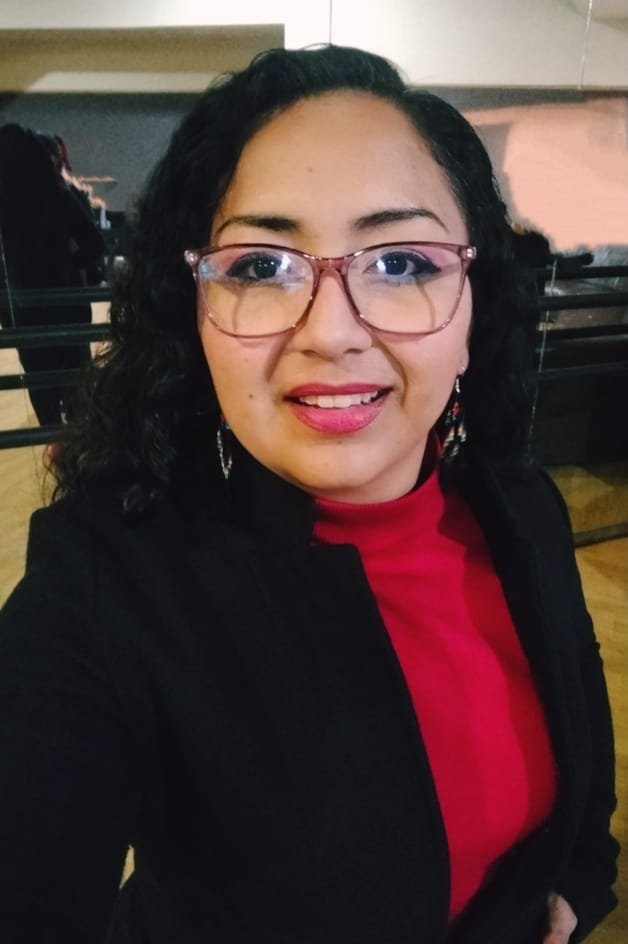 Mujer de lentes con blusa roja y saco negro